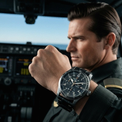Breitling pilot watch on a pilot's wrist, inside a cockpit